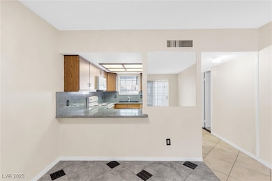 Kitchen featuring  white appliances, visible vents