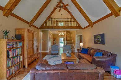 Great room has wood beams and beautiful hardwood floors.