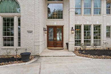 Guests will be impressed with the front covered porch featuring brick flooring and stately wood and leaded glass double front doors topped with a large arched transom window above. The brick is accented with keystone detailing, tall columns, and bronze light fixtures.