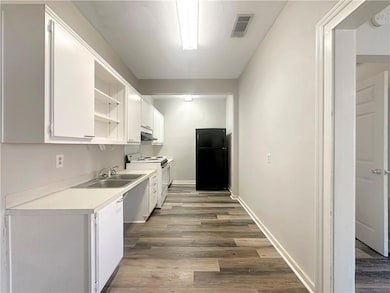Kitchen with dark wood-type flooring, white cabine