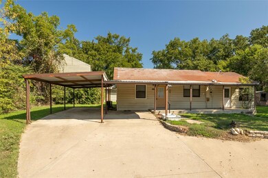 View of front facade featuring a front yard, a car