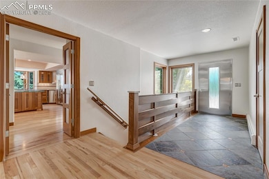 Foyer entrance featuring light wood-style floors, a baseboard heating unit, a textured ceiling, and recessed lighting