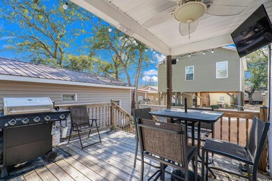 Wooden terrace with a ceiling fan and a grill