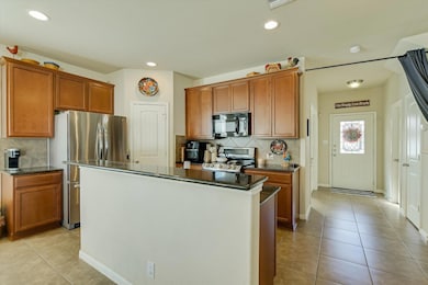 Kitchen featuring tasteful backsplash, stainless steel appliances, light tile patterned flooring, wood cabinets, and recessed lighting