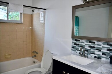 Full bathroom with shower / bathtub combination with curtain, vanity, and tasteful backsplash