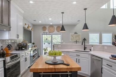 Kitchen with wooden counters, sink, backsplash, an