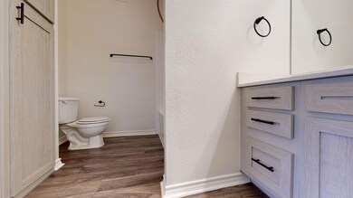 Bathroom with wood finished floors, toilet, and ba