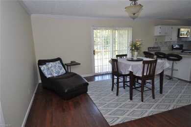 Dining area with wood laminate flooring, slider to rear deck, open to kitchen and living room