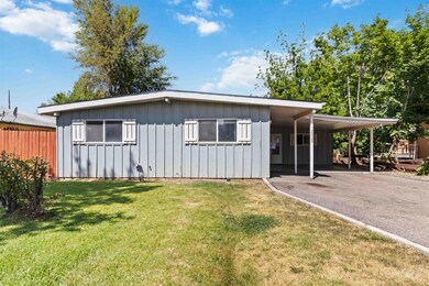 View of front of house featuring board and batten siding, driveway, and an attached carport