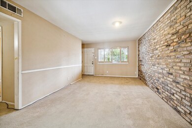 LIVING ROOM WITH LARGE WINDOW OVERLOOKING THE COUR