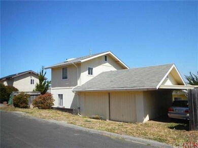 Back of home with garage and carport.