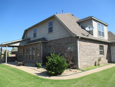 Back of house with covered patio and landscaping.
