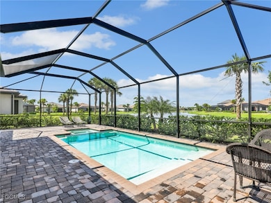 View of swimming pool with a sunroom, a pool with connected hot tub, glass enclosure, a residential view, and a patio area