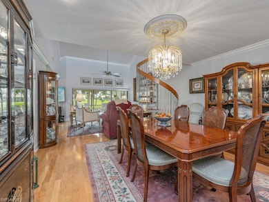 Dining room featuring a ceiling fan, light wood finished floors, a chandelier, and ornamental molding