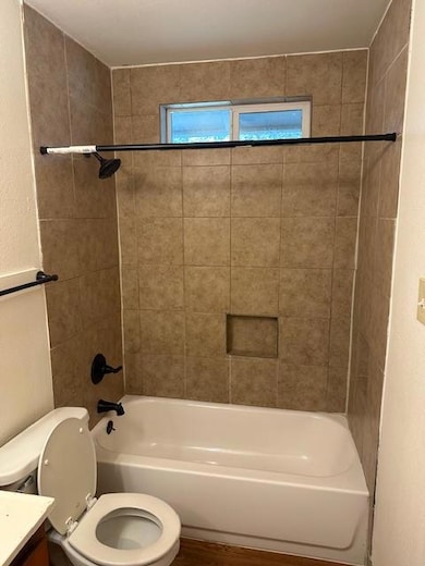 Bathroom with toilet, vanity,  shower combination