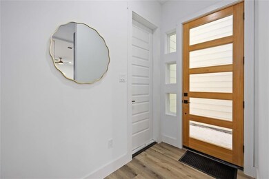 The entry way includes a modern door with glass in