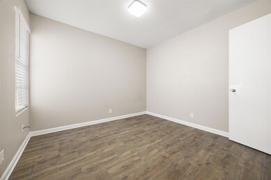 Unfurnished room featuring dark wood-style flooring and baseboards