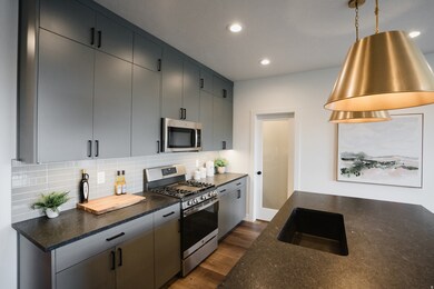 Kitchen with stainless steel appliances, backsplash, dark wood-type flooring, recessed lighting, and pendant lighting