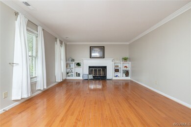 Living room featuring hardwood flooring & crown mo