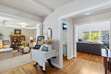 Living area with light wood-style flooring and a tray ceiling