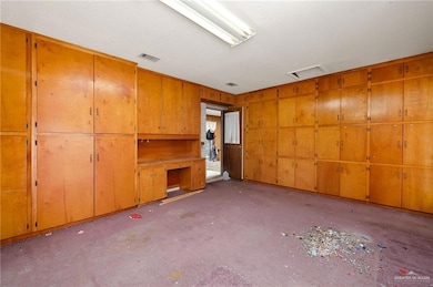 Unfurnished living room featuring attic access
