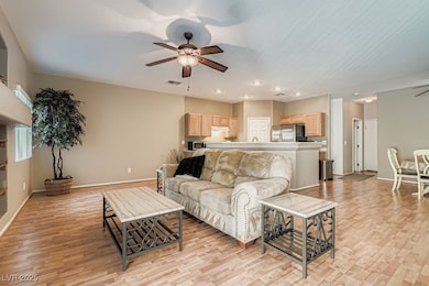 Living room featuring a ceiling fan, recessed lighting, and light wood-style floors