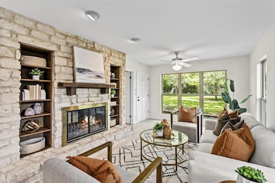 Living area featuring a stone fireplace, ceiling 