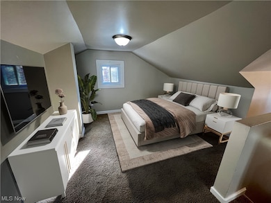 Bedroom with light colored carpet and lofted ceiling
