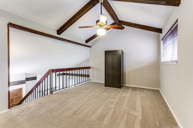 Empty room featuring a ceiling fan, carpet floors, beam ceiling, and high vaulted ceiling