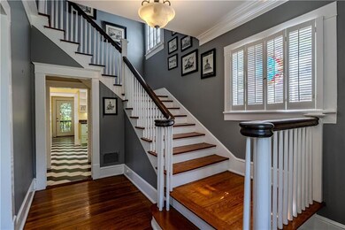 Stairs with wood finished floors and crown molding