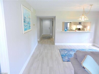 Hallway with a notable chandelier and light wood-t