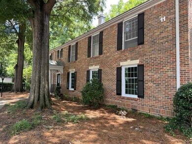 Colonial-style house featuring a chimney and brick siding