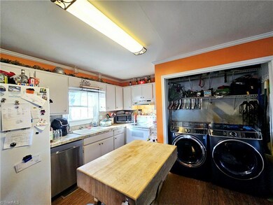 Kitchen with Laundry area. Butcher block island isn't affixed and doesn't stay.