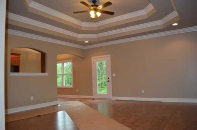 Step into the foyer from the covered front porch!  This space opens nicely to the Great Room offering beautiful laminate HW flooring, a double trey ceiling w/custom millwork, recessed lighting & ceiling fan!