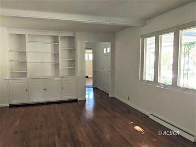 Living room w/ hardwood floor & built in