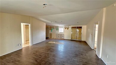 Unfurnished living room featuring lofted ceiling and hardwood / wood-style flooring