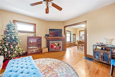 Up unit Living area with ceiling fan and light hardwood / wood-style flooring