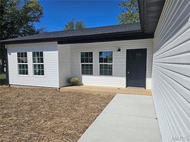 Doorway to property with roof with shingles
