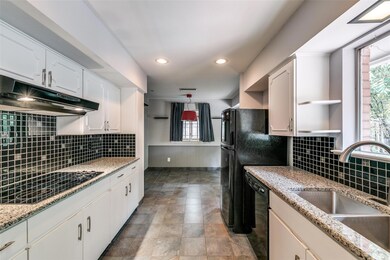 Kitchen featuring decorative backsplash, white cab
