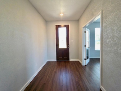 Entryway with a textured wall and dark wood finis