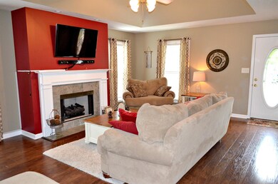 Living room has fireplace, trey ceiling and hardwood floors