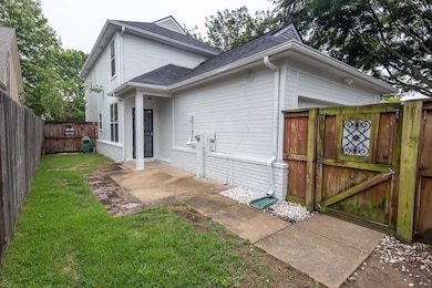 Rear view of property featuring roof with shingles and a gate