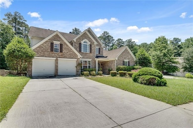 Traditional-style home featuring brick siding, concrete driveway, a front lawn, and roof with shingles