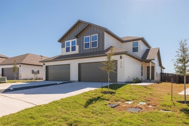 View of front of property with board and batten siding, a garage, and concrete driveway