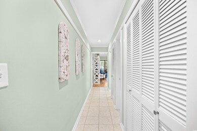 Hallway featuring light tile patterned floors and baseboards