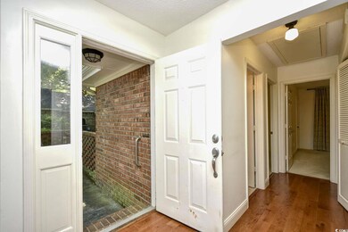 Hall with brick wall, baseboards, and wood finishe