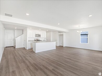 Unfurnished living room with a chandelier, light wood-style floors, and recessed lighting
