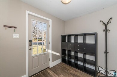 Doorway to outside with dark hardwood / wood-style