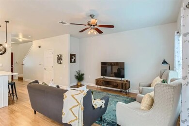 Living room featuring ceiling fan and light wood 