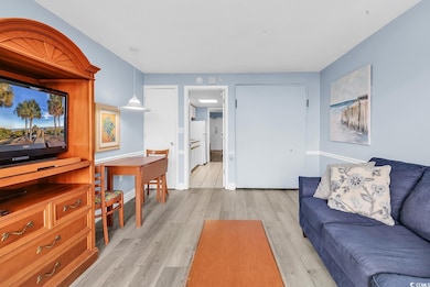 Living area with light wood-style flooring and baseboards